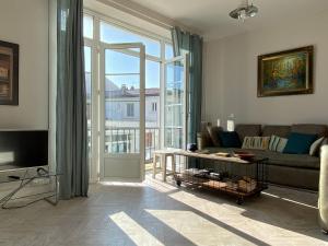 Charmant appartement lumineux et spacieux au centre de Royan - FR-1-738-44 في رويان: غرفة معيشة مع أريكة ونافذة كبيرة