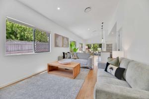 a living room with a couch and a table at Chic Family Friendly 4BR Retreat Near Redcliffe in Scarborough