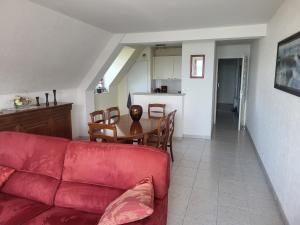 a living room with a red couch and a table at Les Balcons de la Mer in Erquy