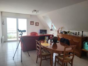 a living room with a table and a couch at Les Balcons de la Mer in Erquy