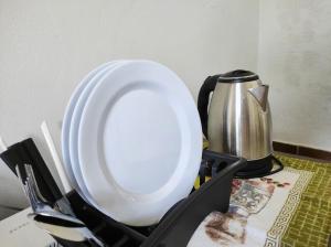 a white plate in a black holder next to a coffee pot at Quarto privativo no Bairro Santa Mônica in Uberlândia