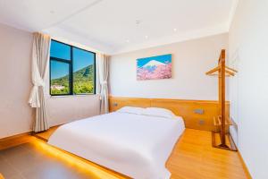 Postel nebo postele na pokoji v ubytování Shenzhen Yusu Linting Seaview Inn Judiaosha Branch