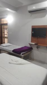 a bed in a room with a tv on a wall at Hotel Abhi family guest house in Lucknow