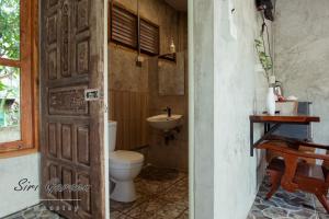 a bathroom with a toilet and a sink at บ้านสวนศิริ Siri Garden in Ban Mang