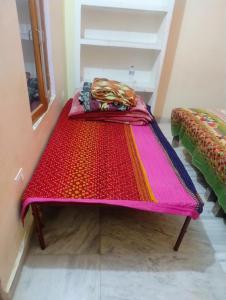a bed with a colorful blanket on it in a room at Manshi Niwas in Prayagraj