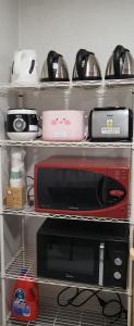 a kitchen shelf with a microwave and other appliances at 서울역 용산 남산뷰 계림 in Seoul