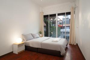 Un dormitorio con una cama y una ventana grande. en Designer house Chao Phraya River - OH Homes 12, en Bangkok
