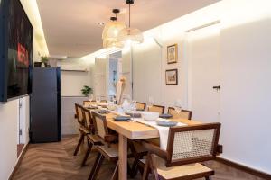 Un comedor con una mesa larga y sillas. en Designer house Chao Phraya River - OH Homes 12, en Bangkok
