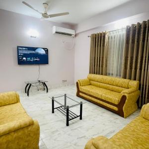 a living room with two couches and a tv at Uttara Luxury Apartment Near Airport & Metro in Dhaka