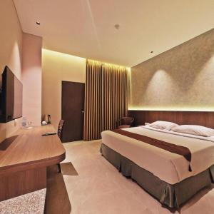 Un dormitorio con una cama grande y un escritorio. en Classic Hotel, en Yakarta
