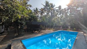 a swimming pool in front of a house with palm trees at Aalmaram By Kizhakeyil Private Pool Heritage Villa in Trivandrum