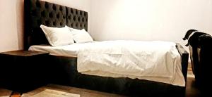 a bedroom with a bed with white sheets and pillows at Varanasi River View Holiday Homestay Dormitory and Hostel in Varanasi