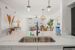 a kitchen with a sink and a living room at Casa Sea-Esta - OCEAN VIEWS in Port Aransas