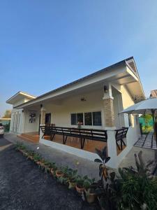 a house with a patio and an umbrella at Chaba 4 family in Nakhon Nayok