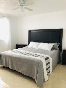 Un dormitorio con una cama grande con ventilador de techo. en Casa Los Arcos, en Oaxtepec