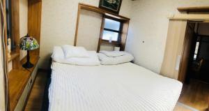 a white bed with white pillows on top of it at Nara House R3 in Kawagoe