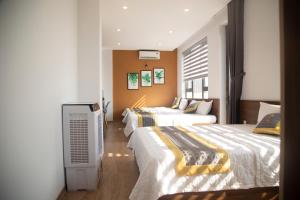a hotel room with two beds and a television at BaKa Hotel - Khách sạn Tuy Hòa in Liên Trì (3)