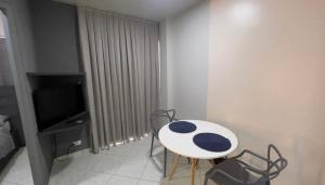 a room with a table and chairs and a television at LOFT no Centro de Joaçaba in Joaçaba