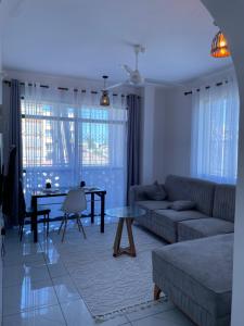 a living room with a couch and a table at Tulivu One-Bedroom Apartment in Mombasa in Mombasa +34 photos