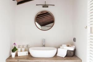 a bathroom with a white tub and a mirror at Salcheto WineHouse in Montepulciano