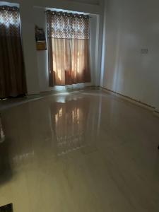 a living room with a concrete floor and a window at Kailashpati Niwas in Prayagraj