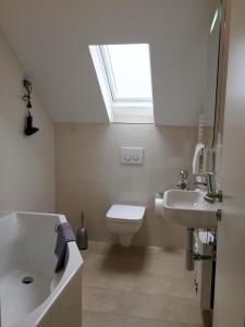 a bathroom with a sink and a toilet and a skylight at Ferienwohnung Kreuder in Bergisch Gladbach