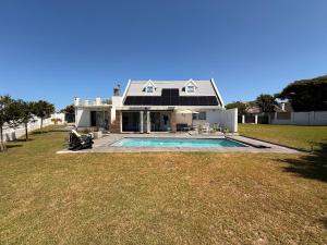 una casa con piscina nel cortile di THE SURF AND GOLF HUIS Solar Power a St Francis Bay