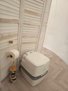 a white toilet in a corner of a bathroom at Entre 2 bulles in Entre-Deux