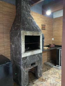 een stenen open haard in een keuken met een aanrecht bij Cop30 aluguel in Belém +10 foto's