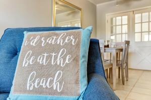 un divano blu con un cuscino con la scritta "Preferirei essere la spiaggia" di 2810 Ohio Avenue #1 a Fernandina Beach
