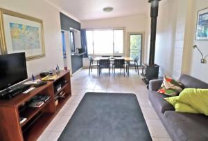 a living room with a couch and a dining room at 14 Broome Street in Mallacoota