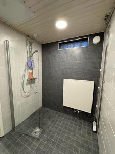 baño con ducha con una pizarra blanca en la pared en Ketunpesä Puijolla, en Kuopio 12 fotos más