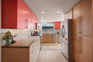 a large kitchen with red cabinets and a refrigerator at NW Nest 30 Day Minimum in Bend +30 photos