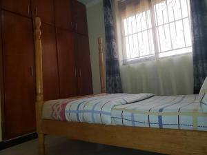 a bedroom with a bed and a window at safari chic retreat in Kampala in Kampala