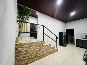 a staircase in a living room with a kitchen at Teyú Green Cottage in Cuatro Esquinas