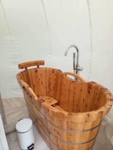 a wooden bath tub with a faucet in a bathroom at Entre 2 bulles in Entre-Deux