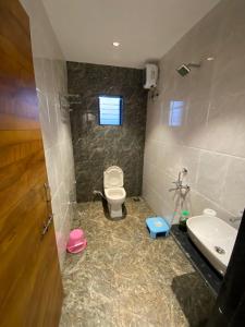 a bathroom with a toilet and a sink at PARAM RESORT in Mahabaleshwar