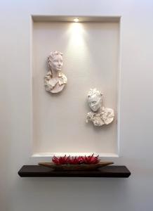 two busts on a wall with a plate on a shelf at Double Eagle in Rancho Mirage