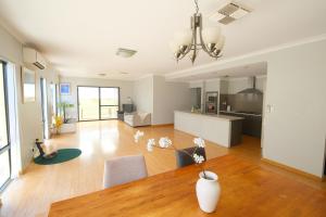 ein Wohnzimmer mit Tisch und Küche in der Unterkunft Airport 5BR Retreat - Full Kitchen & Tranquil in Perth