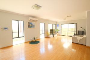 ein leeres Wohnzimmer mit Hartholzboden in der Unterkunft Airport 5BR Retreat - Full Kitchen & Tranquil in Perth