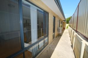 einen leeren Flur eines Gebäudes mit Fenstern in der Unterkunft Airport 5BR Retreat - Full Kitchen & Tranquil in Perth