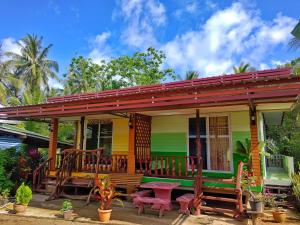 a colorful house with a porch and a bench at KohLibong Beach House Homestay in Ban Batubute