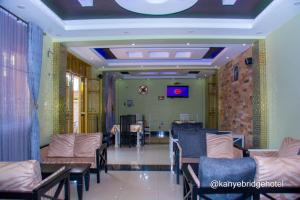 a waiting room with couches and tables in a building at Kanye Bridge Hotel Jinja in Jinja