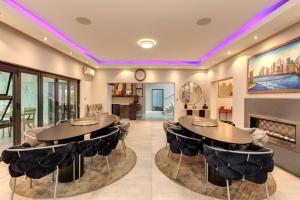 een woonkamer met 2 tafels en een open haard bij Braham Lodge - The Octave in Johannesburg