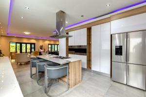 een open keuken met een eiland met barkrukken bij Braham Lodge - The Octave in Johannesburg