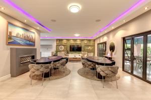 een woonkamer met 2 tafels en een open haard bij Braham Lodge - The Octave in Johannesburg