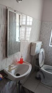 a bathroom with a sink and a toilet and a mirror at New sharma homestay in Prayagraj