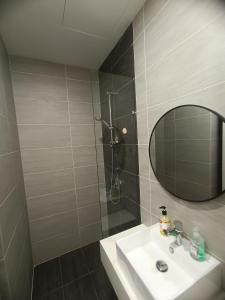 a bathroom with a sink and a shower with a mirror at Trion Residence Kuala Lumpur by Azure in Kuala Lumpur
