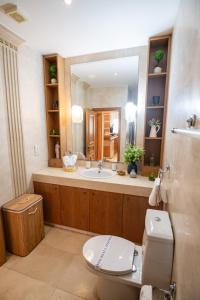 a bathroom with a toilet and a sink and a mirror at Quattro Beachfront Sea View Ap 4 in Larnaka +43 photos