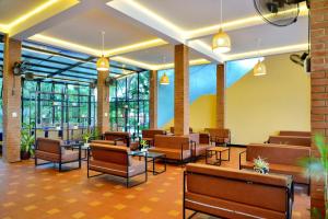 a lobby with chairs and tables and windows at Thai Hoa Mui Ne Resort in Mui Ne
